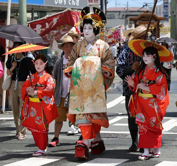 花魁と禿炎天下の中、練り歩く若者達
